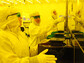 Technicians in a clean room learn how to operate the equipment used to make semiconductors.
